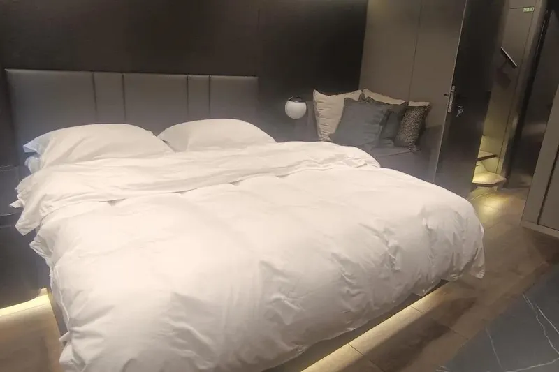  Yacht Photos Pics Luxurious bedroom interior on 2021 Sunreef 80 Power yacht, featuring a cozy bed and modern decor.