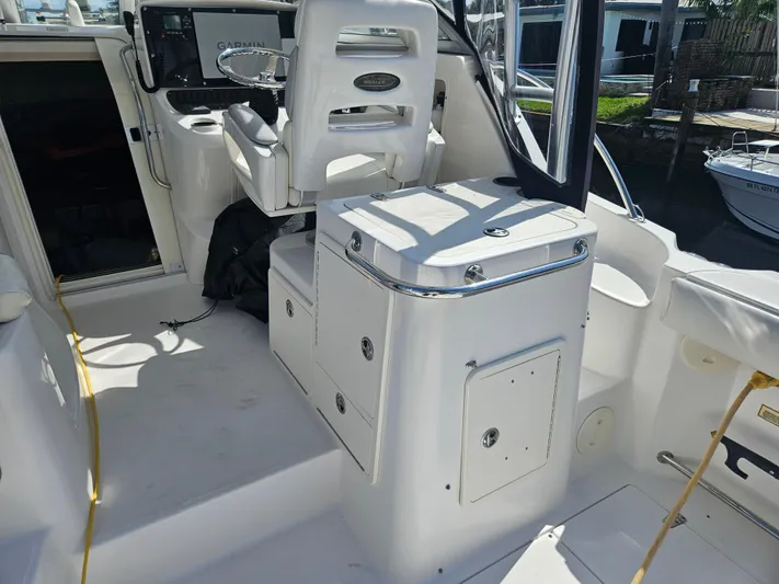  Yacht Photos Pics 2005 Boston Whaler 305 Conquest cockpit with helm seat and storage compartments.