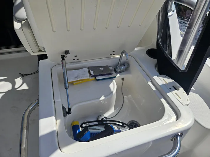  Yacht Photos Pics Open storage compartment on 2005 Boston Whaler 305 Conquest boat, containing various items.