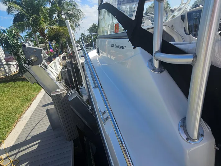  Yacht Photos Pics 2005 Boston Whaler 305 Conquest docked, showcasing sleek design and sturdy railing.
