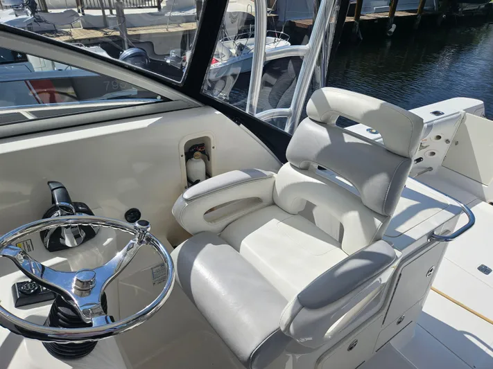  Yacht Photos Pics 2005 Boston Whaler 305 Conquest helm with steering wheel and comfortable captain's chair.