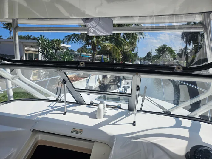  Yacht Photos Pics 2005 Boston Whaler 305 Conquest cockpit view with tropical canal backdrop.