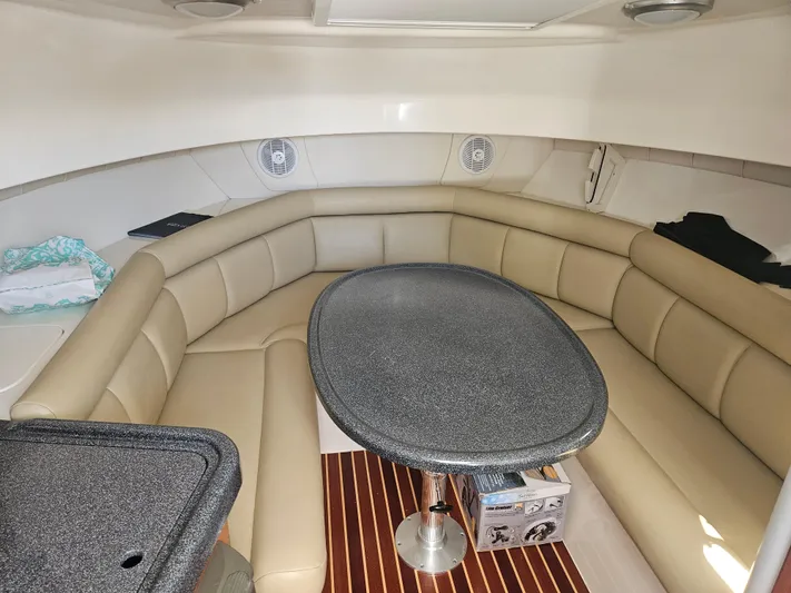  Yacht Photos Pics Luxurious interior of 2005 Boston Whaler 305 Conquest with beige seating and oval table.