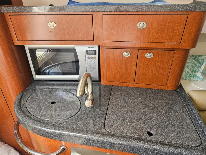  Yacht Photos Pics Compact kitchen area in a 2005 Boston Whaler 305 Conquest boat with microwave and sink.