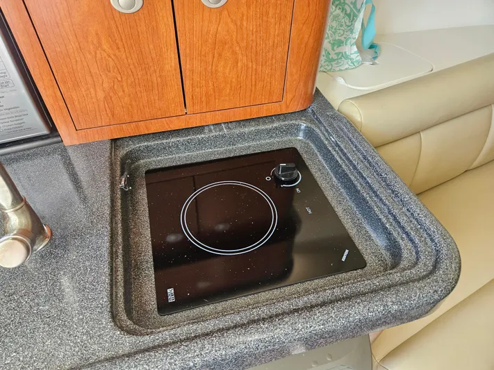  Yacht Photos Pics 2005 Boston Whaler 305 Conquest interior with stove and wooden cabinetry.