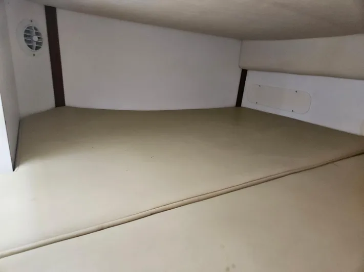  Yacht Photos Pics Interior cabin of a 2005 Boston Whaler 305 Conquest boat, featuring beige cushions.