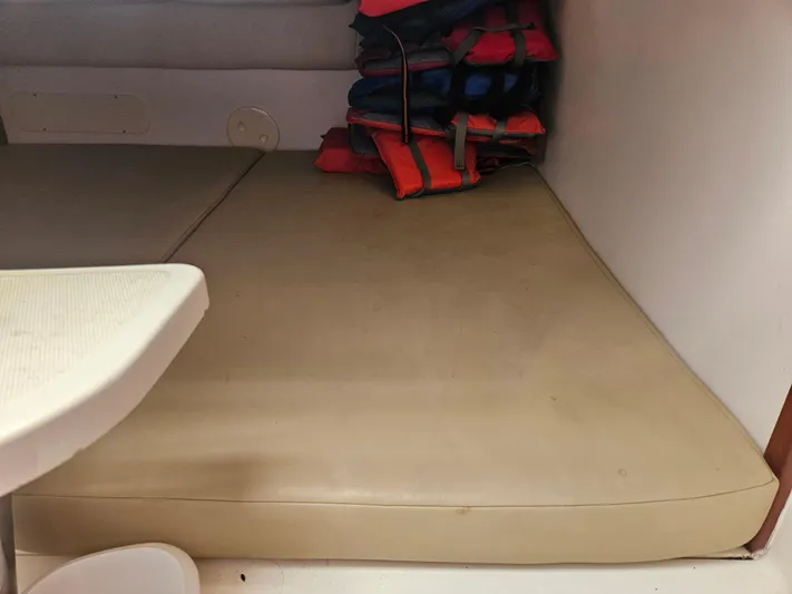  Yacht Photos Pics 2005 Boston Whaler 305 Conquest cabin interior with life jackets on a beige cushion.