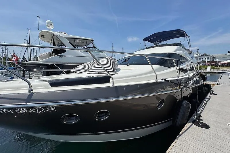  Yacht Photos Pics 2012 Marquis 500 Sport Bridge yacht docked at marina under clear blue sky.