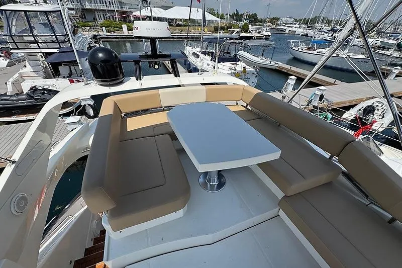  Yacht Photos Pics Luxurious 2012 Marquis 500 Sport Bridge yacht with spacious outdoor seating and table at marina.
