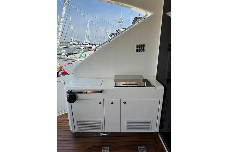  Yacht Photos Pics Outdoor kitchen on 2012 Marquis 500 Sport Bridge yacht, featuring grill and storage cabinets.