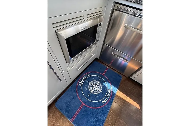  Yacht Photos Pics 2012 Marquis 500 Sport Bridge kitchen with stainless steel appliances and nautical-themed rug.