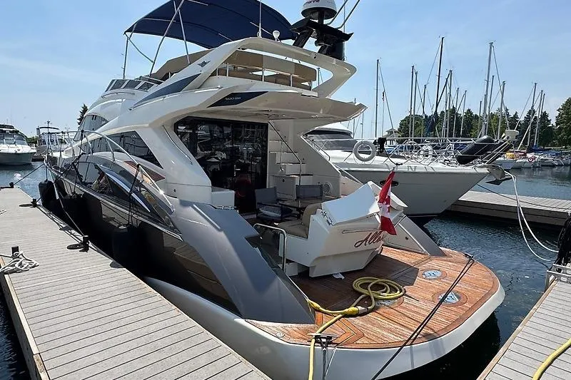  Yacht Photos Pics 2012 Marquis 500 Sport Bridge yacht docked at marina, featuring sleek design and spacious deck.