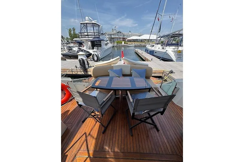  Yacht Photos Pics Luxury 2012 Marquis 500 Sport Bridge yacht with elegant outdoor seating at marina.