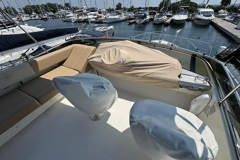  Yacht Photos Pics 2012 Marquis 500 Sport Bridge yacht deck with covered seating, docked at marina.