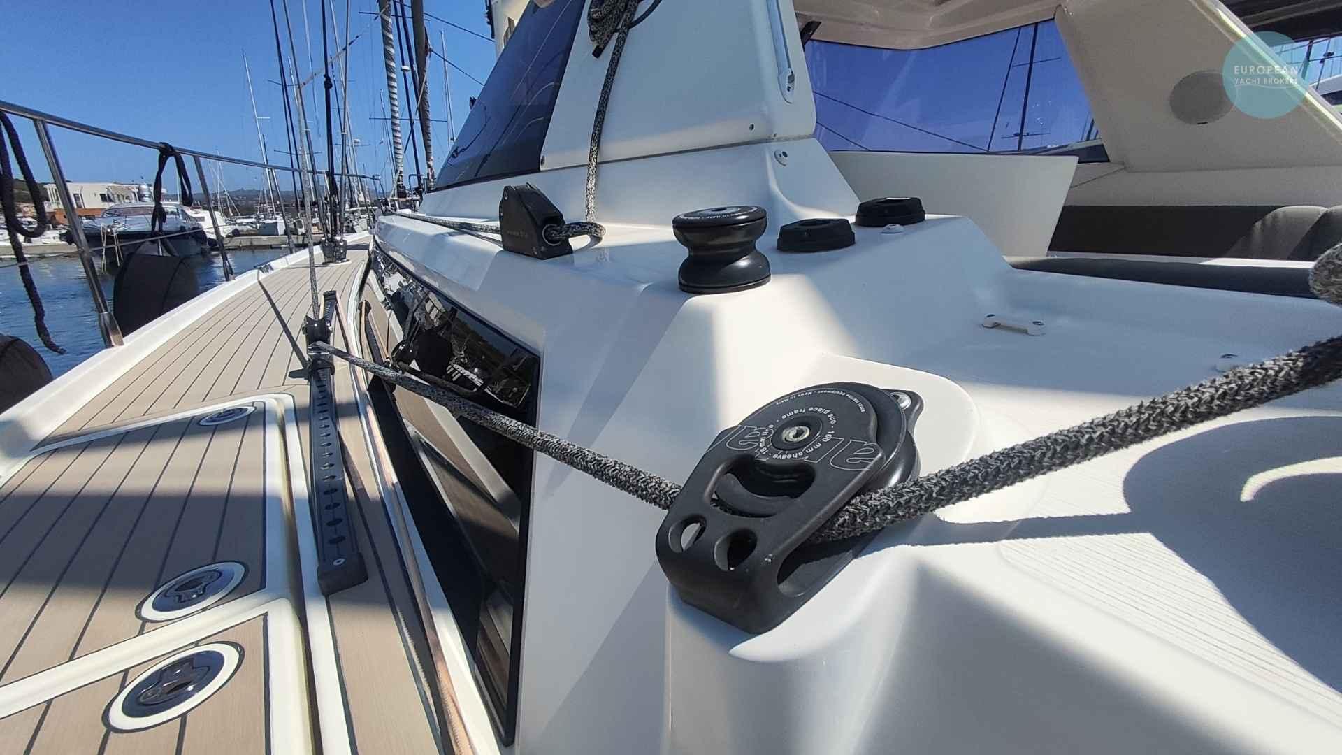 Deck view of 2017 Amel 55 yacht, showcasing rigging and sleek design in marina setting.