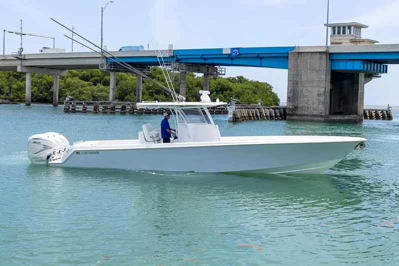  Yacht Photos Pics 2023 Contender 39 ST boat cruising near a bridge in calm waters.