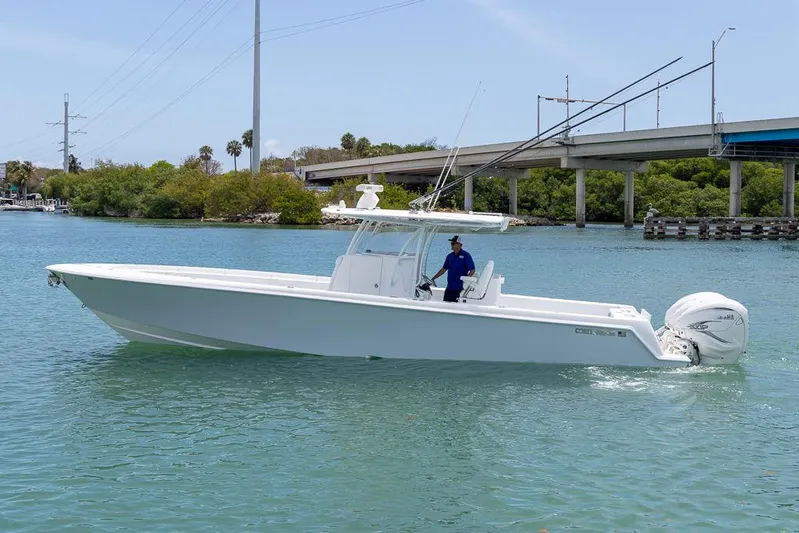  Yacht Photos Pics 2023 Contender 39 ST boat cruising on a sunny day near a bridge.