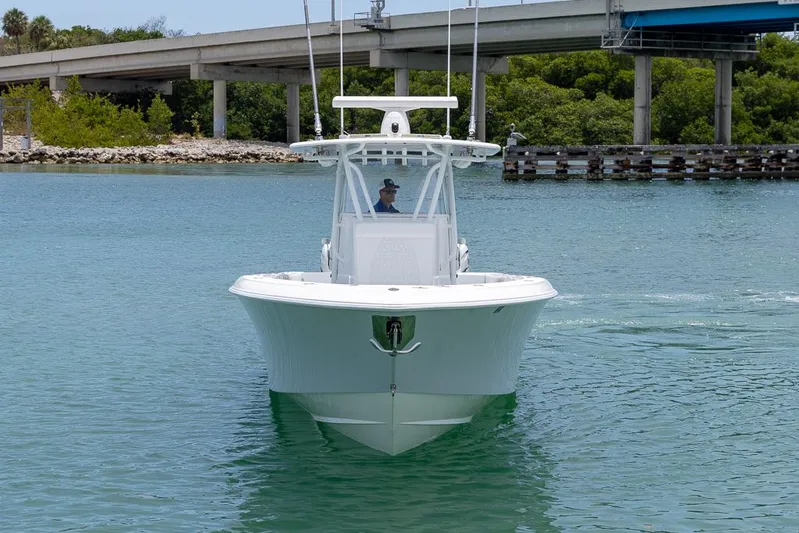  Yacht Photos Pics 2023 Contender 39 ST boat cruising on calm water near a bridge.