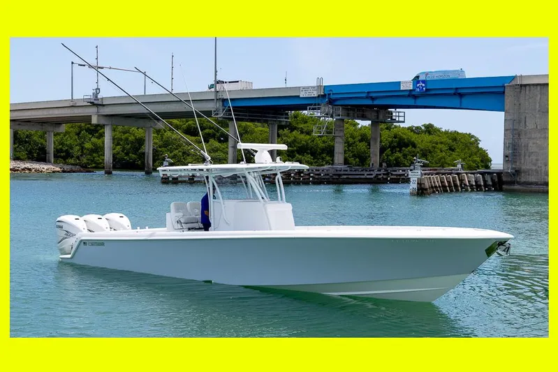  Yacht Photos Pics 2023 Contender 39 ST boat on water near a bridge, featuring triple outboard engines.