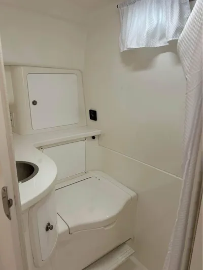  Yacht Photos Pics Compact bathroom in a 2002 Intrepid 348 WA boat, featuring a toilet and sink.