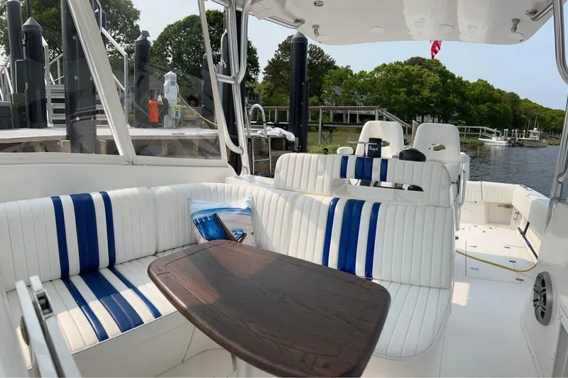  Yacht Photos Pics Interior of 2002 Intrepid 348 WA boat with striped seating and wooden table.