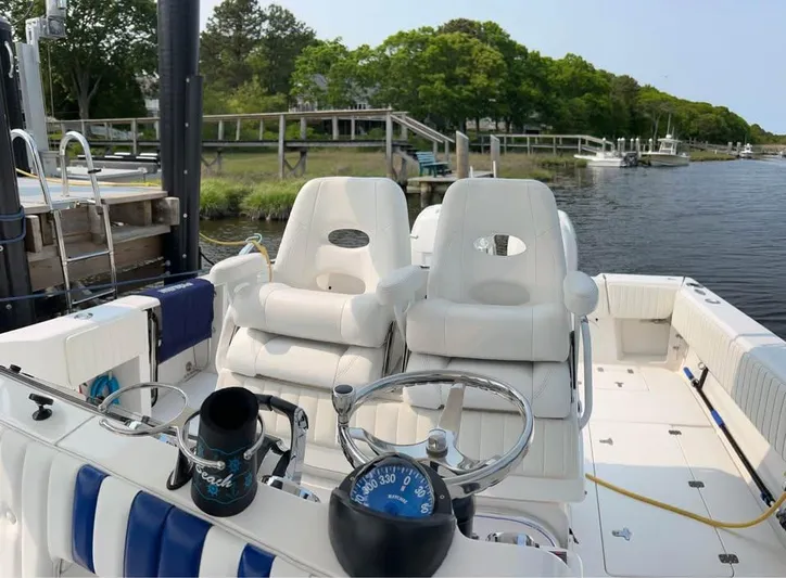  Yacht Photos Pics 2002 Intrepid 348 WA boat interior with white seating, steering wheel, and compass docked by a scenic river.