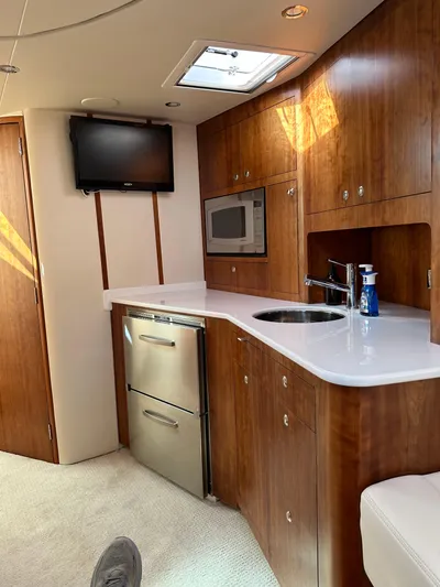 Still Wreckless Yacht Photos Pics 2014 SeaVee 430 SE yacht interior with kitchenette, featuring wood cabinets, sink, and appliances.