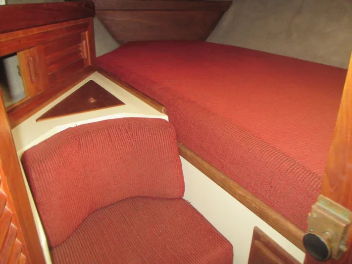  Yacht Photos Pics Cozy cabin interior of 1990 Pacific Seacraft 37 with red upholstery and wooden accents.