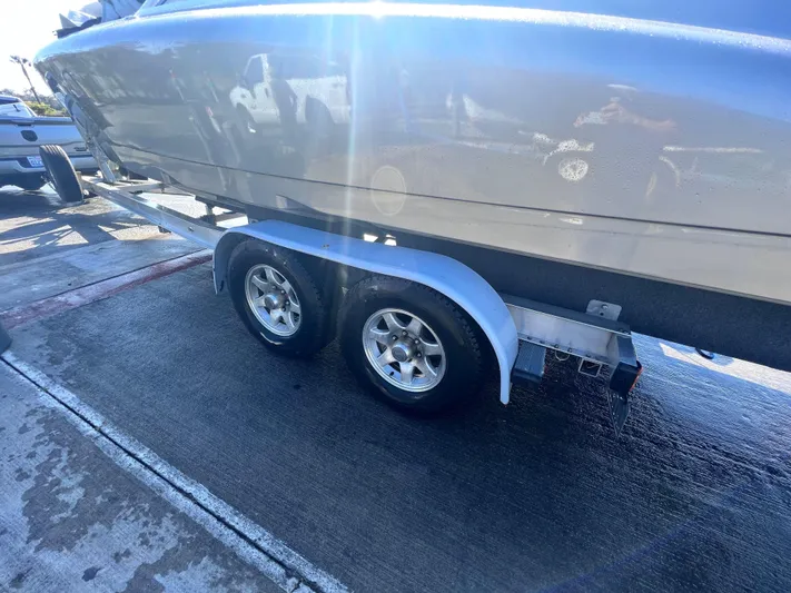 Unique Yacht Photos Pics Trailer with a 2008 Porsche Donzi boat, parked on a wet pavement.