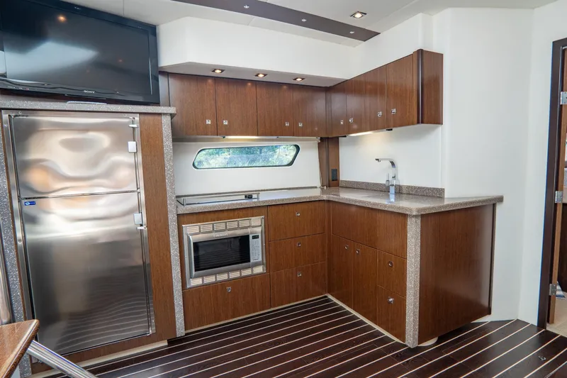 Epic Yacht Photos Pics Luxurious kitchen interior of 2013 Cruisers Yachts 48 Cantius with modern appliances and wood finish.