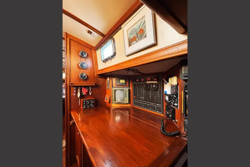 Makani Yacht Photos Pics Navigation station of 1993 Gozzard 44 MK1 AC sailboat with wooden finish and control panels.