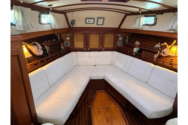 Makani Yacht Photos Pics Cozy interior of 1993 Gozzard 44 MK1 AC sailboat with white cushioned seating.