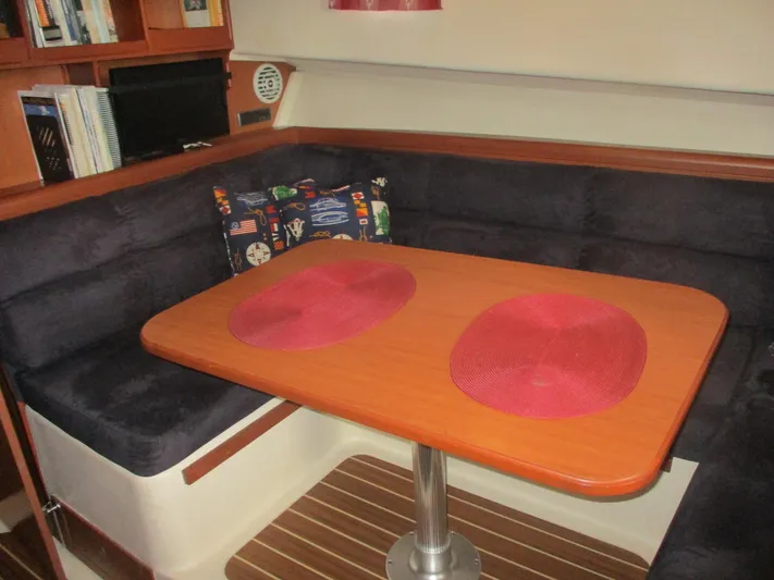  Yacht Photos Pics 2007 Mainship Pilot 34 Sedan interior with dining table, cushioned seating, and decorative pillows.