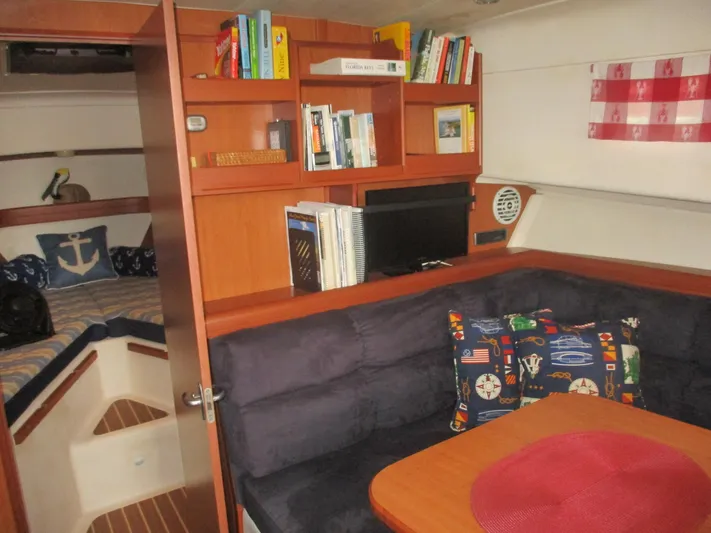  Yacht Photos Pics 2007 Mainship Pilot 34 Sedan interior with cozy seating, bookshelf, and nautical decor.