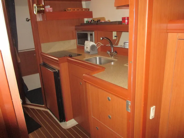  Yacht Photos Pics 2007 Mainship Pilot 34 Sedan interior kitchen with wood cabinetry and modern appliances.
