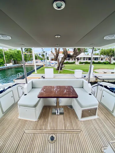 Ivy Therapy Yacht Photos Pics 2015 Azimut 50 yacht deck with seating and table, docked by waterfront homes.