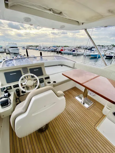 Ivy Therapy Yacht Photos Pics 2015 Azimut 50 yacht helm with marina view, featuring modern controls and wooden deck.