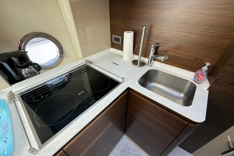 Ivy Therapy Yacht Photos Pics Modern kitchen in 2015 Azimut 50 yacht with stove, sink, and porthole window.