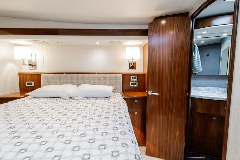 Trailer Trash Yacht Photos Pics Luxurious bedroom interior of 2021 Viking 58 Convertible yacht with elegant wood finishes.