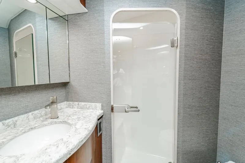 Trailer Trash Yacht Photos Pics Luxurious bathroom in 2021 Viking 58 Convertible yacht with marble countertop and modern shower.