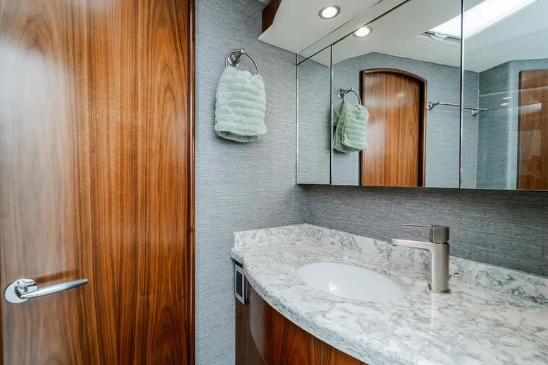 Trailer Trash Yacht Photos Pics Luxurious bathroom in 2021 Viking 58 Convertible yacht with marble countertop and wooden accents.