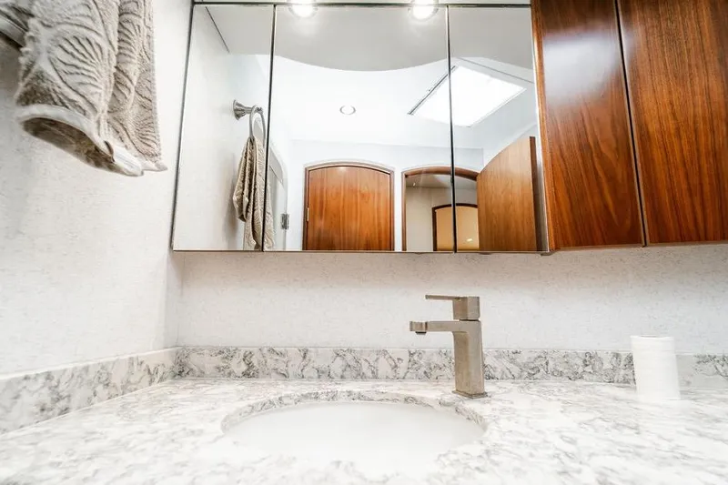 Trailer Trash Yacht Photos Pics Modern bathroom vanity in 2021 Viking 58 Convertible yacht, featuring marble countertop and wooden cabinets.