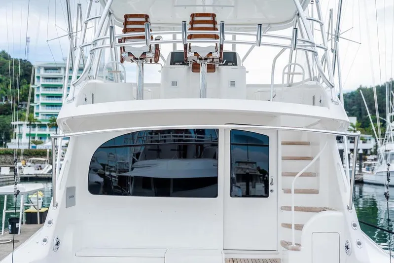 Trailer Trash Yacht Photos Pics 2021 Viking 58 Convertible yacht docked at marina, featuring sleek design and upper deck seating.