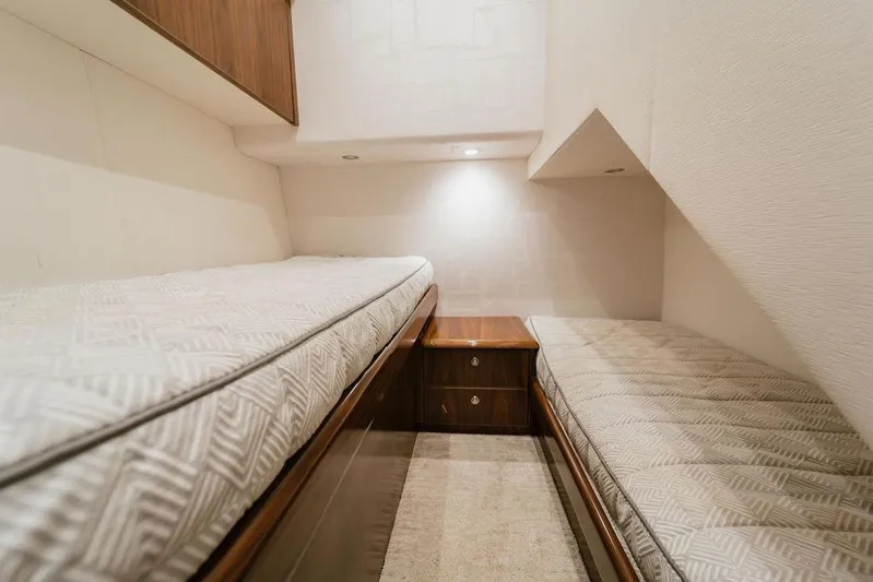 Trailer Trash Yacht Photos Pics Interior of 2021 Viking 58 Convertible yacht with twin beds and wooden cabinetry.