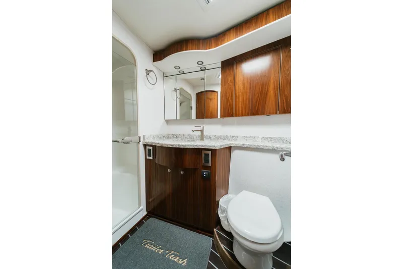 Trailer Trash Yacht Photos Pics Luxurious bathroom in 2021 Viking 58 Convertible yacht with wood cabinetry and modern fixtures.