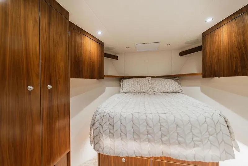 Trailer Trash Yacht Photos Pics Luxurious cabin interior of 2021 Viking 58 Convertible yacht with cozy bed and wooden cabinets.
