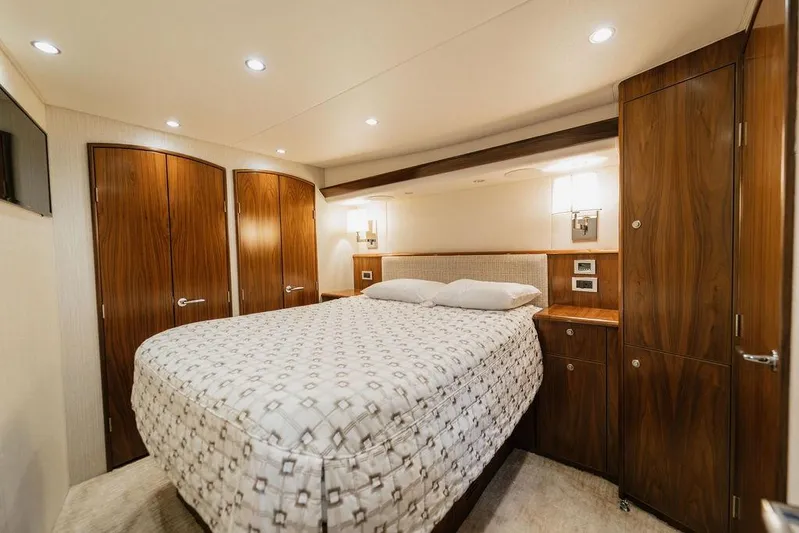 Trailer Trash Yacht Photos Pics Luxurious bedroom interior of 2021 Viking 58 Convertible yacht with wood accents.