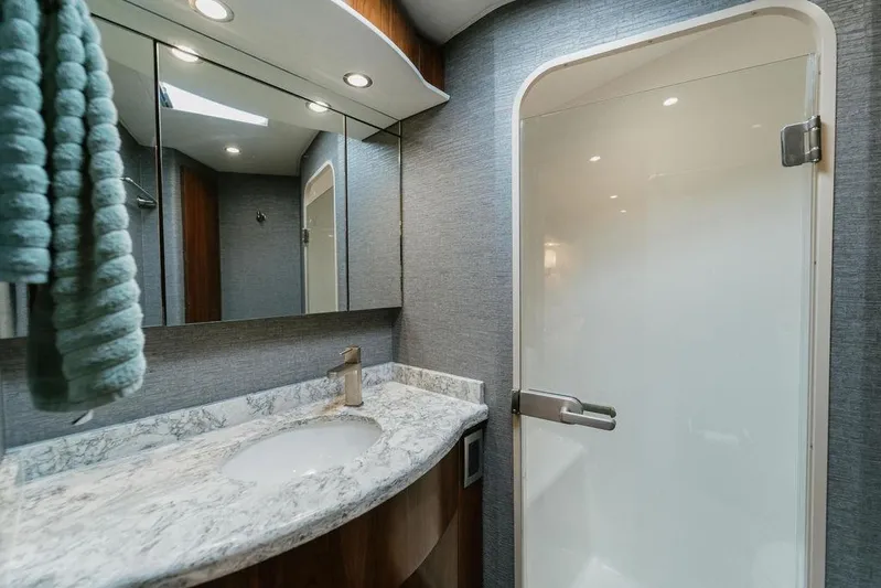 Trailer Trash Yacht Photos Pics Luxurious bathroom in 2021 Viking 58 Convertible yacht with marble countertop and modern fixtures.