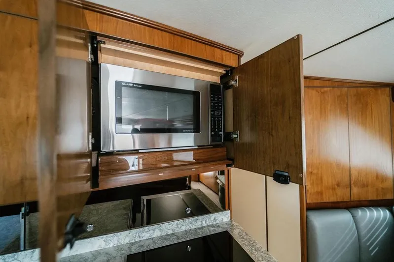 Trailer Trash Yacht Photos Pics Microwave in 2021 Viking 58 Convertible yacht kitchen with wooden cabinetry.