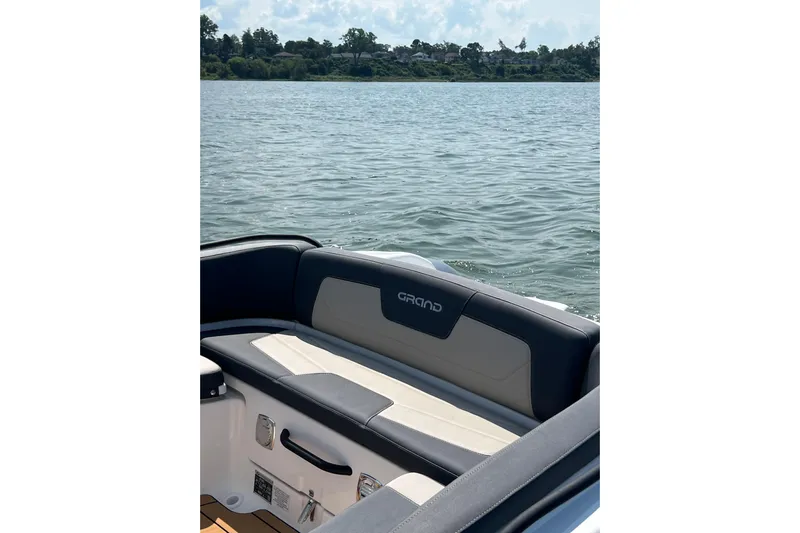  Yacht Photos Pics 2025 Grand Inflatables G850 boat interior with cushioned seating, overlooking a serene lake.